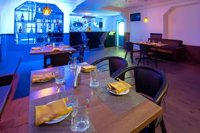 a restaurant with a wooden table and chairs with yellow napkins at Zip by Spree Hotels Mangala International in Coimbatore