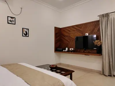 a bedroom with a bed and a tv on a wall at The Cana's Coorg in Ammatti