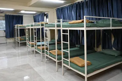 a group of bunk beds in a room with blue curtains at The Green Room Residency in Padinjarathara