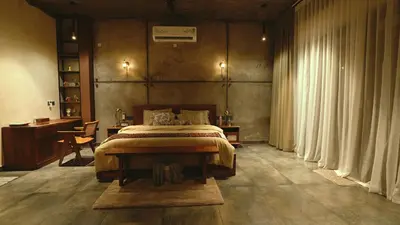a bedroom with a bed and a desk and curtains at Lofterra in Kozhikode