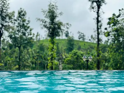 a pool of water with trees in the background at Marina Homestay in Devāla