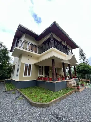 a large house with a balcony on top of it at Marina Homestay in Devāla