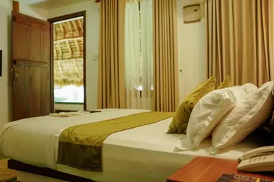 a bedroom with a large bed with pillows on it at Bamboo Grove in Mānantoddy
