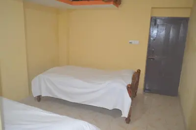 a room with two beds and a black cabinet at Kalpavruksha Farmstay by StayApart in Madikeri