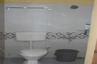 a bathroom with a toilet and a trash can at Kalpavruksha Farmstay by StayApart in Madikeri