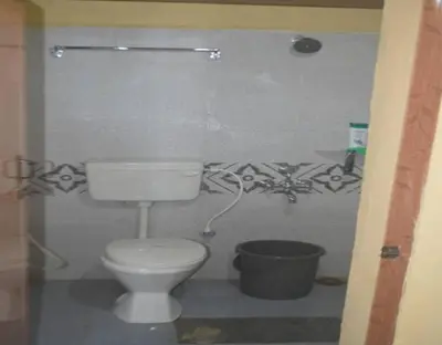 a bathroom with a white toilet in a room at Kalpavruksha Farmstay by StayApart in Madikeri