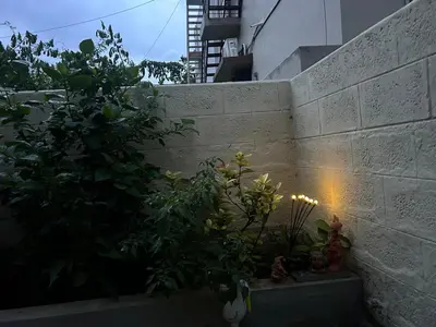 a concrete wall with plants in a garden at SHI's Isha Homestay in Coimbatore in Coimbatore