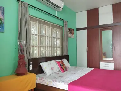 a bedroom with a bed with a pink blanket and a window at SHI's Isha Homestay in Coimbatore in Coimbatore