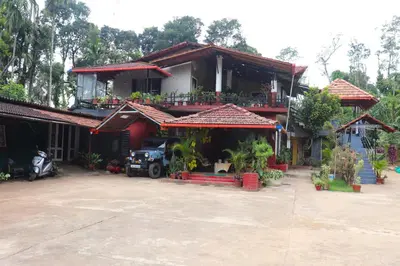 a house with a car parked in front of it at Coorg Northbreeze Estate stay in Madikeri