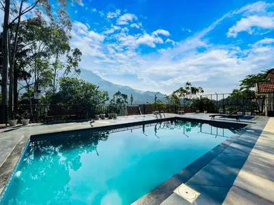 a swimming pool with a view of mountains at Dazzle Villa Resort in Kalpetta
