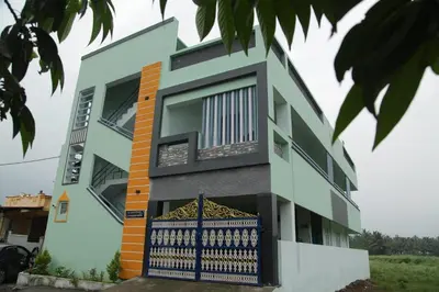 a building with a blue gate in front of it at SHI's Peaceful Oasis near Isha Adiyogi, Kovai Kuttralam Waterfalls & Karunya University in Alāndurai