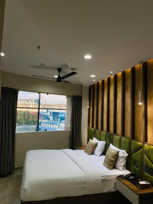 a bedroom with a large bed with a large window at Mezkar Residency in Alwaye