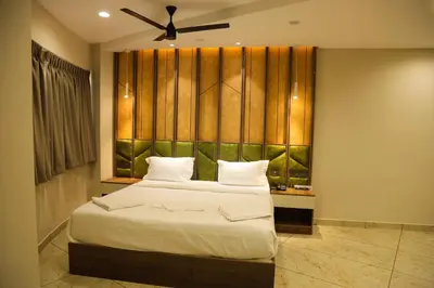 a bedroom with a large bed and a ceiling fan at Mezkar Residency in Alwaye