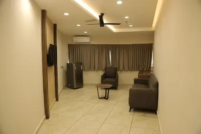 a living room with a couch and chairs and a television at Mezkar Residency in Alwaye