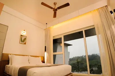 a bedroom with a bed and a large window at Leaves Resort Vythiri Wayanad in Vythiri