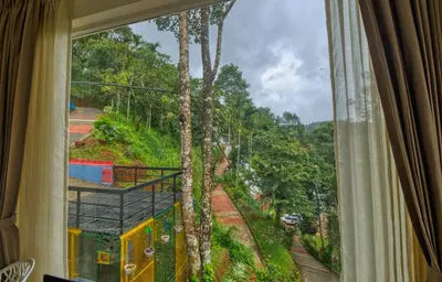 a room with a window with a view of a forest at Ende Wayanad Resort in Koroth
