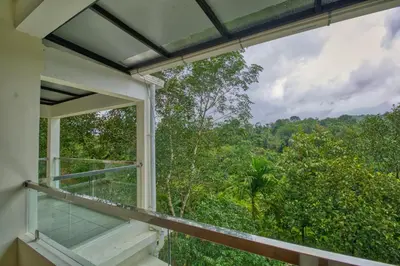 a balcony with a view of the forest at Ende Wayanad Resort in Koroth