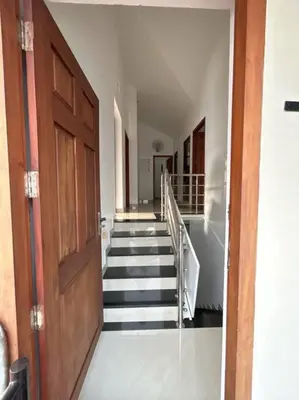 a hallway with stairs and a wooden door at Saaketh Holiday Home(2) in Kozhikode