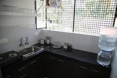 a kitchen with a sink and a bottle of water at Saaketh Holiday Home(2) in Kozhikode