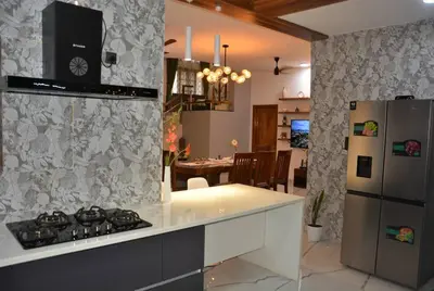 a kitchen with a stove and a refrigerator at Earth - Luxurious 5 BHK AC Villa at Mysore in Mysore