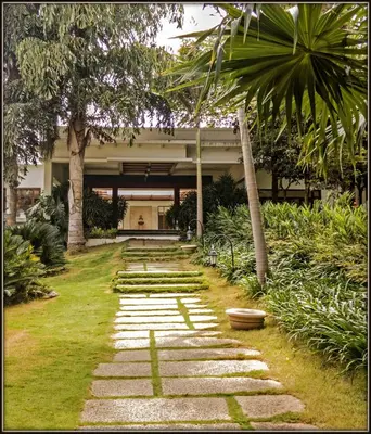 a garden with a stone path in front of a building at Club Mahindra Golden Landmark, Mysuru in Mysore