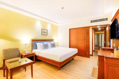 a hotel room with a bed and a television at Club Mahindra Golden Landmark, Mysuru in Mysore