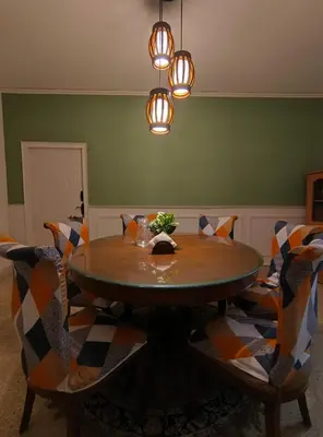 a dining room with a wooden table and chairs at Nama-Stay - An escape villa in Ooty