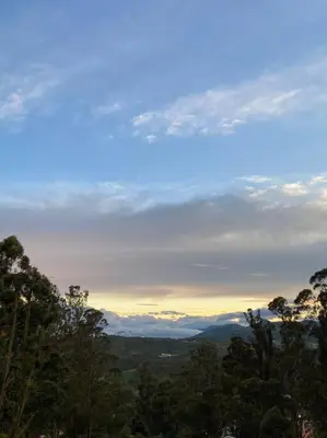 a view of a mountain range with trees in the foreground at Nama-Stay - An escape villa in Ooty