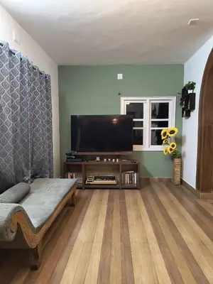 a living room with a couch and a flat screen tv at Nama-Stay - An escape villa in Ooty