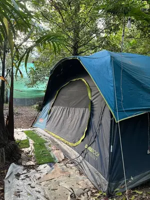 a blue tent sitting on the ground next to trees at Dragster Tents in Kizhake Chālakudi