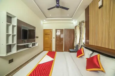 a hotel room with a bed and a tv at AVJ Nest, Kodaikanal in Kodaikānāl