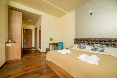 a bedroom with two beds with white towels on them at Sri Vidhya Residency by Indo Stays in Kotagiri