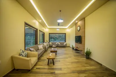 a living room with couches and a table at Sri Vidhya Residency by Indo Stays in Kotagiri