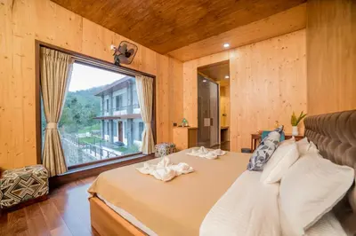 a bedroom with a bed and a large window at Sri Vidhya Residency by Indo Stays in Kotagiri