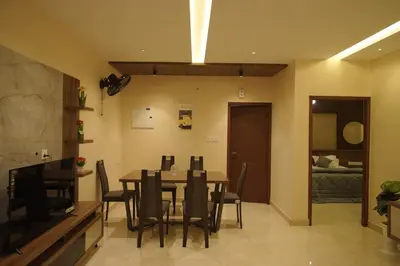 a dining room with a table and chairs at Ncomforts Luxurious Apartments in Perintalmanna