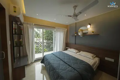 a bedroom with a bed and a large window at Ncomforts Luxurious Apartments in Perintalmanna