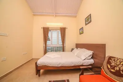 a bedroom with a bed and a chair and a window at The Springs by Indo Stays in Yedapalli