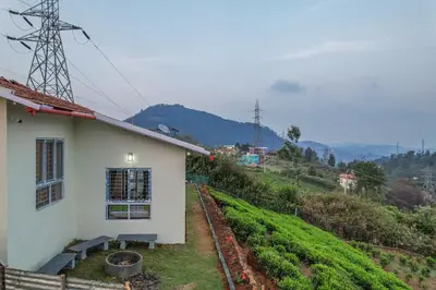 a white house with a view of a hill at The Springs by Indo Stays in Yedapalli
