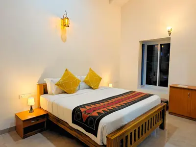 a bedroom with a large bed with a window at Ibex Resorts, Kotagiri in Kotagiri