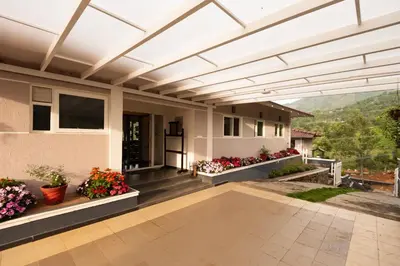 a porch of a house with flowers at Ibex Resorts, Kotagiri in Kotagiri