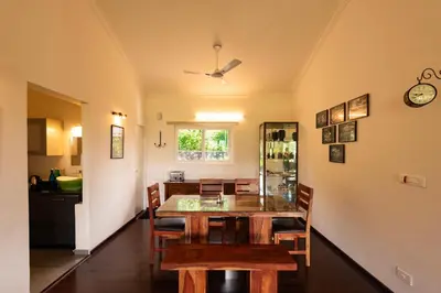 a dining room with a glass table and chairs at Ibex Resorts, Kotagiri in Kotagiri