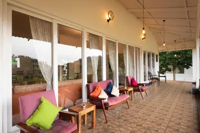 a lobby with colorful chairs and windows at Ibex Resorts, Kotagiri in Kotagiri