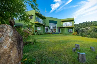 a green house with a yard in front of it at ama Stays & Trails Anjanagiri , Kotagiri in Kotagiri
