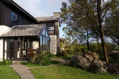 a house with a large window on the side of it at StayVista at Little Heaven with Breakfast in Ooty