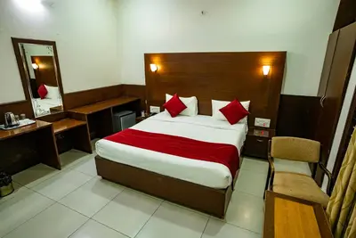 a hotel room with a bed and a mirror at Nijaguna Resorts in Chāmrājnagar