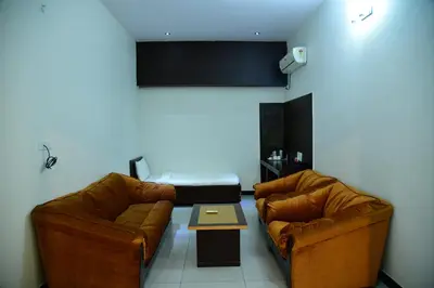 a living room with two brown leather couches and a table at Nijaguna Resorts in Chāmrājnagar