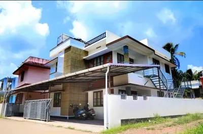a building with a motorcycle parked in front of it at DREAMS VILLA Near Rajagiri Hospital in Alwaye
