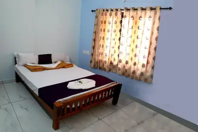 a bedroom with a bed and a curtain at DREAMS VILLA Near Rajagiri Hospital in Alwaye