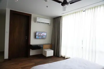 a bedroom with a bed and a tv on the wall at Royal Holidays & Stays in Pattāmbi