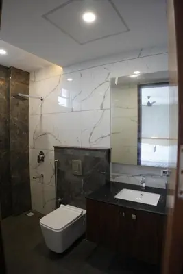 a bathroom with a toilet and a sink and a mirror at Royal Holidays & Stays in Pattāmbi